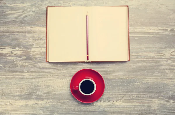 Livro e xícara de café na mesa de madeira . — Fotografia de Stock