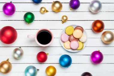 Fincan kahve ve macaron uyumak arka plan üzerinde Noel oyuncaklar ile