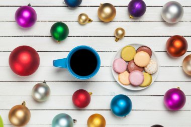 Fincan kahve ve macaron uyumak arka plan üzerinde Noel oyuncaklar ile