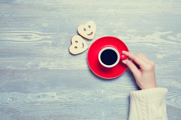 Kvinnliga händer med kopp kaffe och kaka. — Stockfoto