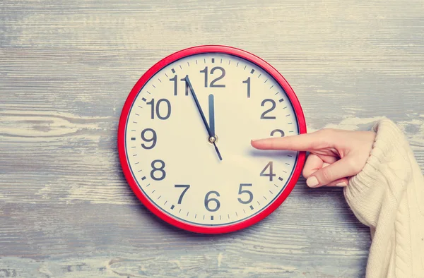 Female hand and clock on a table. — Stock Photo, Image