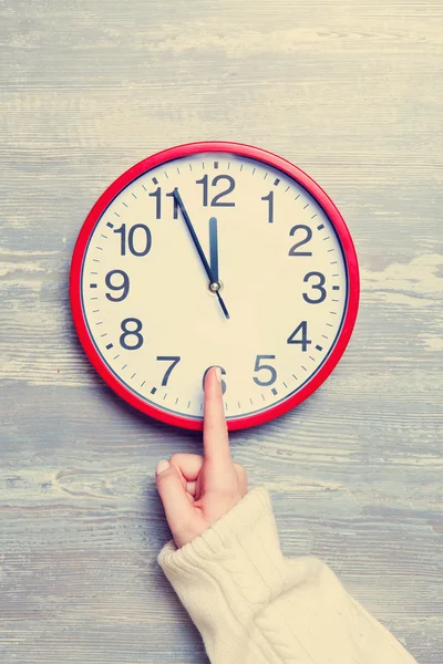 Female hand and clock on a table. — Stock Photo, Image