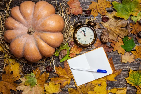 Reloj despertador y nota con pluma en la mesa de otoño . — Foto de Stock