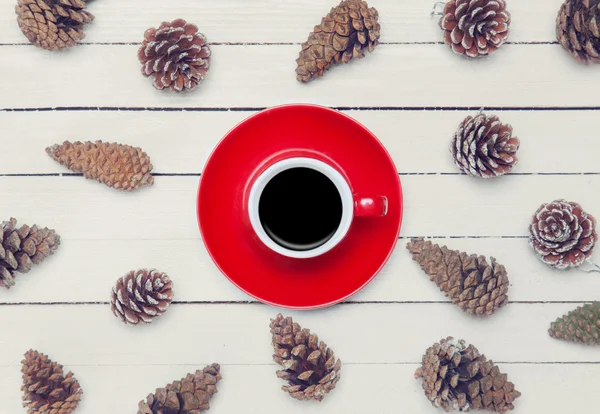 Cup of coffee and pine cone on a white table. — Stock Photo, Image