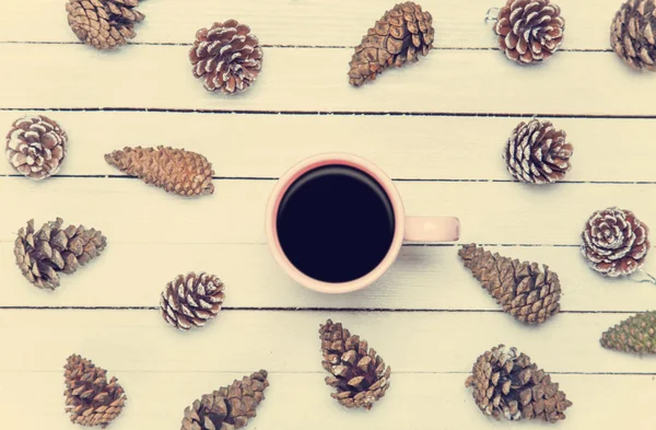 Cup of coffee and pine cone on a white table. — Stock Photo, Image