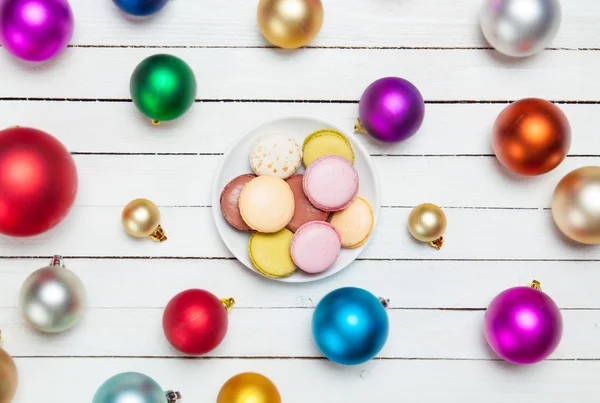 Macaron on plate and christmas balls around. — Stock Photo, Image