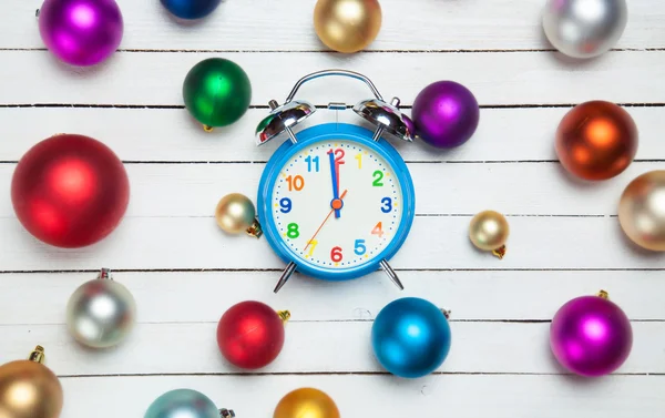 Alarm clock and christmas balls on white table. — Stock Photo, Image