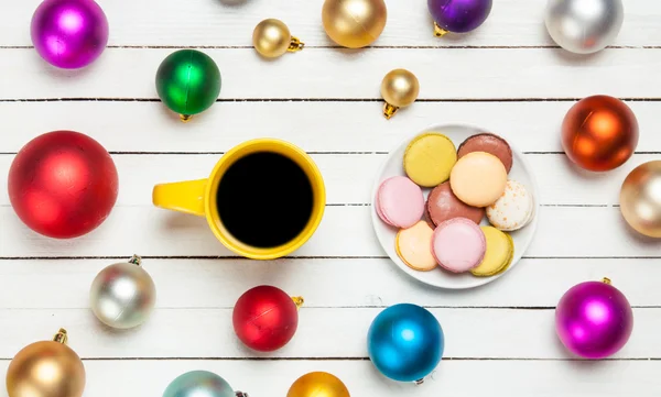 Cup of coffee and macaron with christmas toys on whte background — Stock Photo, Image