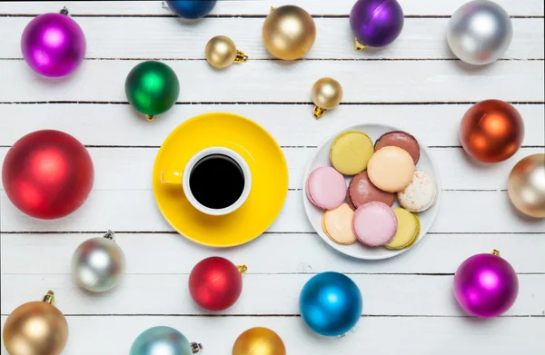 Cup of coffee and macaron with christmas toys on whte background — Stock Photo, Image