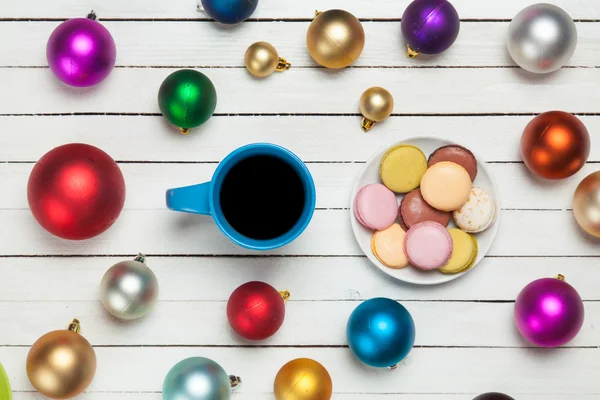 Cup of coffee and macaron with christmas toys on whte background — Stock Photo, Image