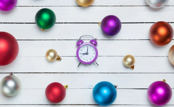 Alarm clock and christmas balls on white table. — Stock Photo, Image