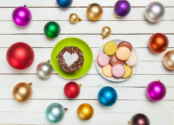 Macaron y magdalena cerca de juguetes de Navidad . —  Fotos de Stock