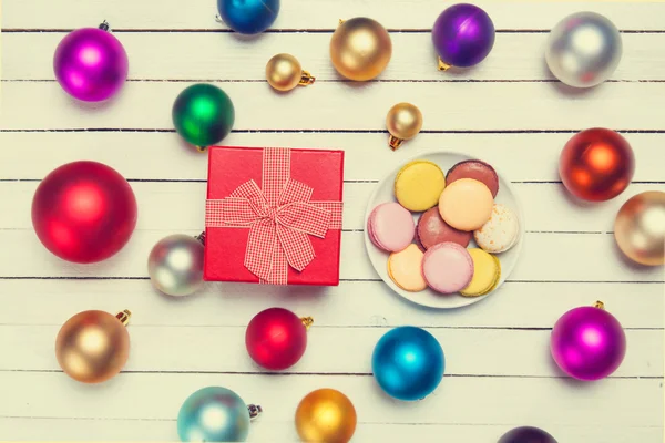 Macaron y regalo cerca de juguetes de Navidad . — Foto de Stock