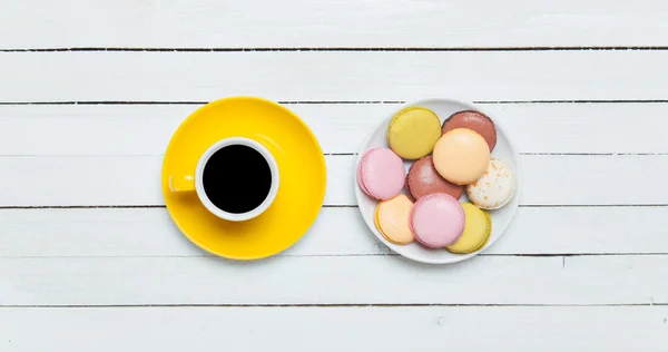 Taza de café y macaron sobre mesa de madera . —  Fotos de Stock