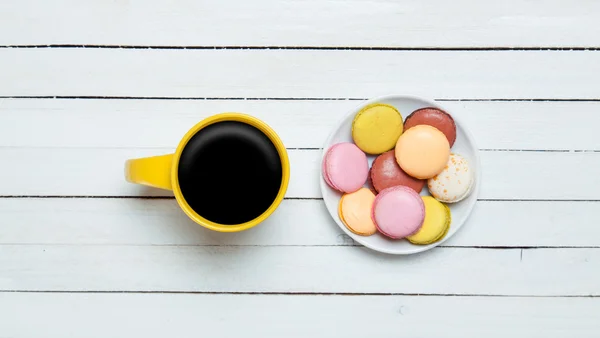 Cup of coffee and macaron on wooden table. — Stock Photo, Image