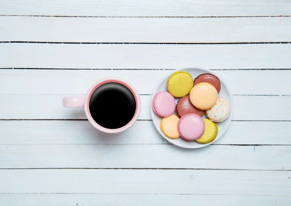 Cup of coffee and macaron on wooden table. — Stock Photo, Image