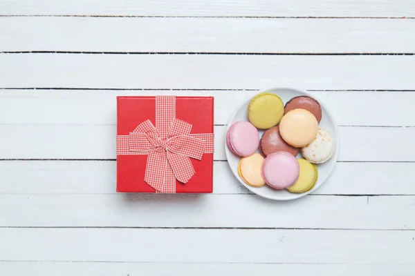Macaron e regalo su tavola bianca . — Foto Stock