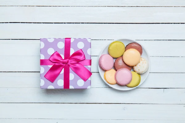 Macaron e regalo su tavola bianca . — Foto Stock