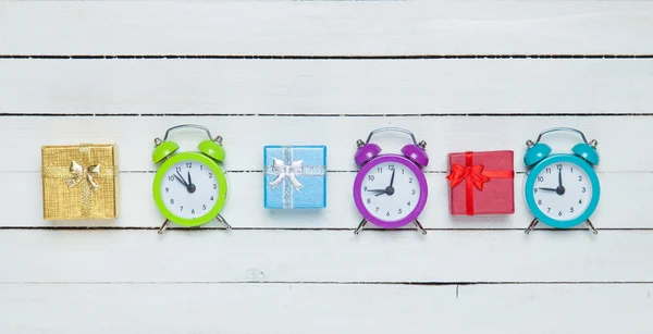 Caixas de presente e relógios lalrm no fundo branco . — Fotografia de Stock
