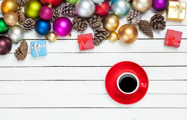 Filiżankę kawy i Boże Narodzenie zabawki na stół biały. — Zdjęcie stockowe