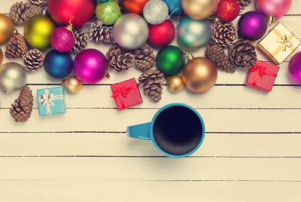 Cup of coffee and christmas toys on white table. — Stock Photo, Image