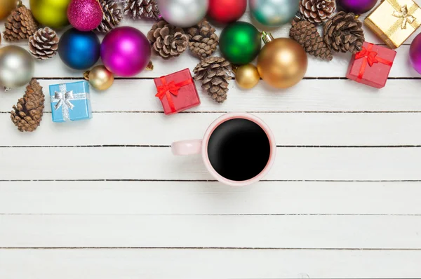 Secangkir kopi dan mainan natal di atas meja putih . — Stok Foto