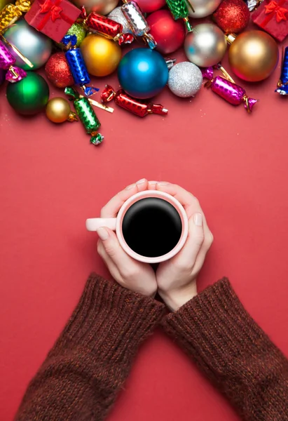 Mädchen hält Tasse Kaffee in der Nähe von Weihnachtsspielzeug. — Stockfoto