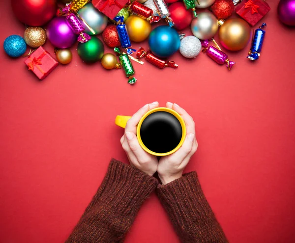 Flicka håller kopp kaffe nära jul leksaker. — Stockfoto