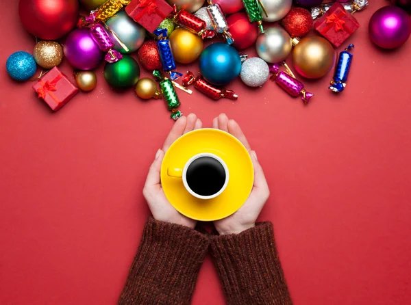 Kahve Noel oyuncaklar yakınındaki tutan kız. — Stok fotoğraf