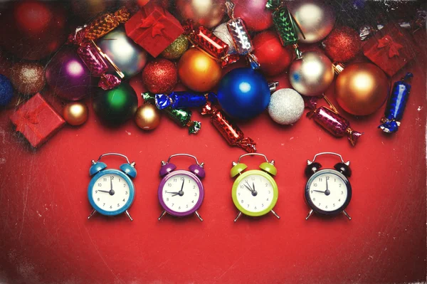 Four clocks near christmas gifts. — Stock Photo, Image