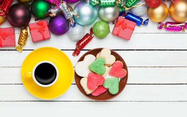 Cup of coffee and cookie with christmas toys on whte background. — Stock Photo, Image