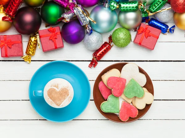 Cup of coffee and cookie with christmas toys on whte background. — Stock Photo, Image