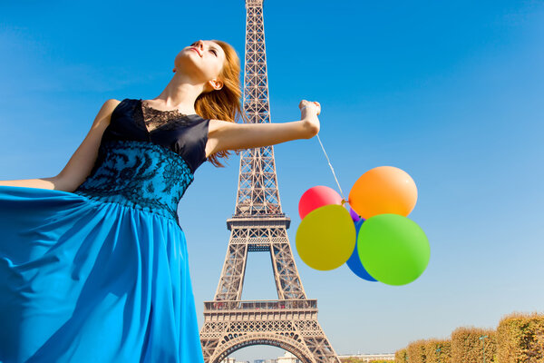 Redhead girl with colour balloons on parisian Eiffel tower backg