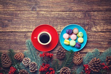 Fincan kahve ve macaron Çamın dalları ahşap bir masa üzerinde yakınındaki.