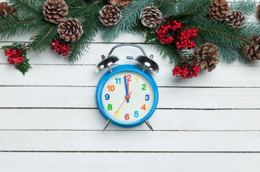 Çamın dalları ahşap masa üzerinde yakınındaki çalar saat.