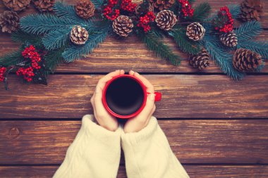 Çamın dalları yakınındaki kahve tutan kız