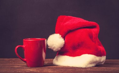 Noel babalar şapka ve Kupası bir tablo.