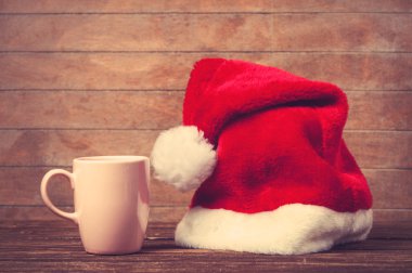 Noel babalar şapka ve Kupası bir tablo.