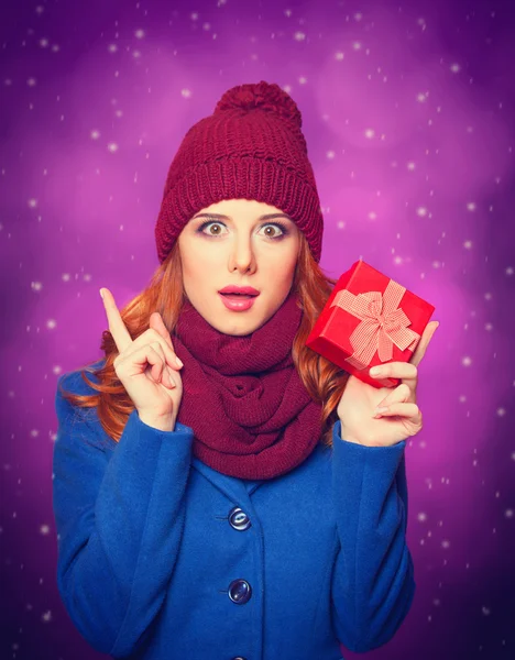 Ragazza rossa con regalo su sfondo viola . — Foto Stock