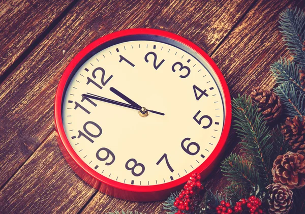 Alarm clock near Pine branches on wooden table. — Stock Photo, Image