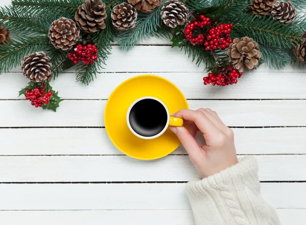 Girl holding cup of coffee near Pine branches — Stock Photo, Image