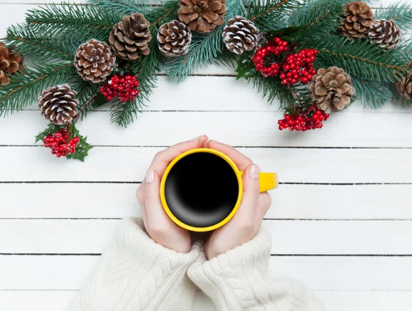 Flicka håller kopp kaffe nära Pine grenar — Stockfoto