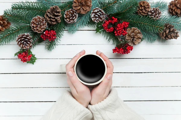 Girl holding cup of coffee near Pine branches — Stock Photo, Image