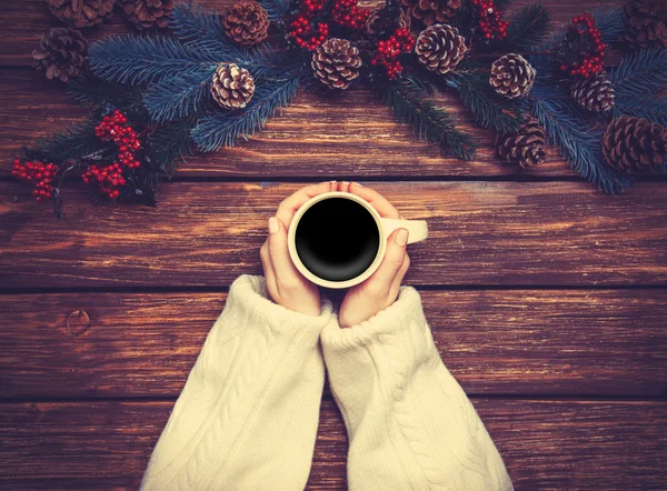 Mädchen hält Tasse Kaffee in der Nähe von Kiefernzweigen — Stockfoto