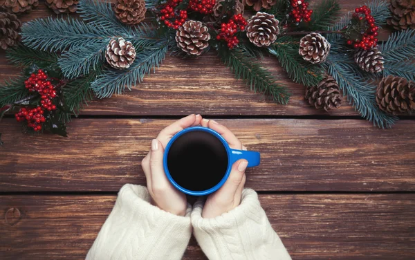 Flicka håller kopp kaffe nära Pine grenar — Stockfoto