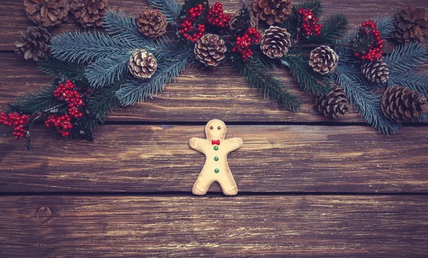 Gingerbread man on a table near pine branches — Stock Photo, Image