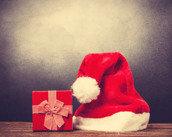 Cappello Babbo Natale rosso e confezione regalo su un tavolo di legno . — Foto Stock