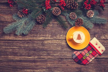 Noel ağacı şeklinde ahşap bir masa üzerinde sıcak cappuccino 