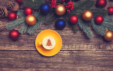 Noel ağacı şeklinde ahşap bir masa üzerinde sıcak cappuccino 