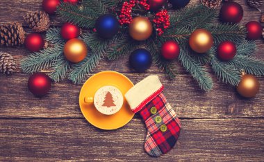 Noel ağacı şeklinde ahşap bir masa üzerinde sıcak cappuccino 